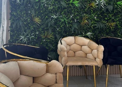 Stylish chairs with a green backdrop at Beige Beauty Center in Sharjah, Sharjah, AE.