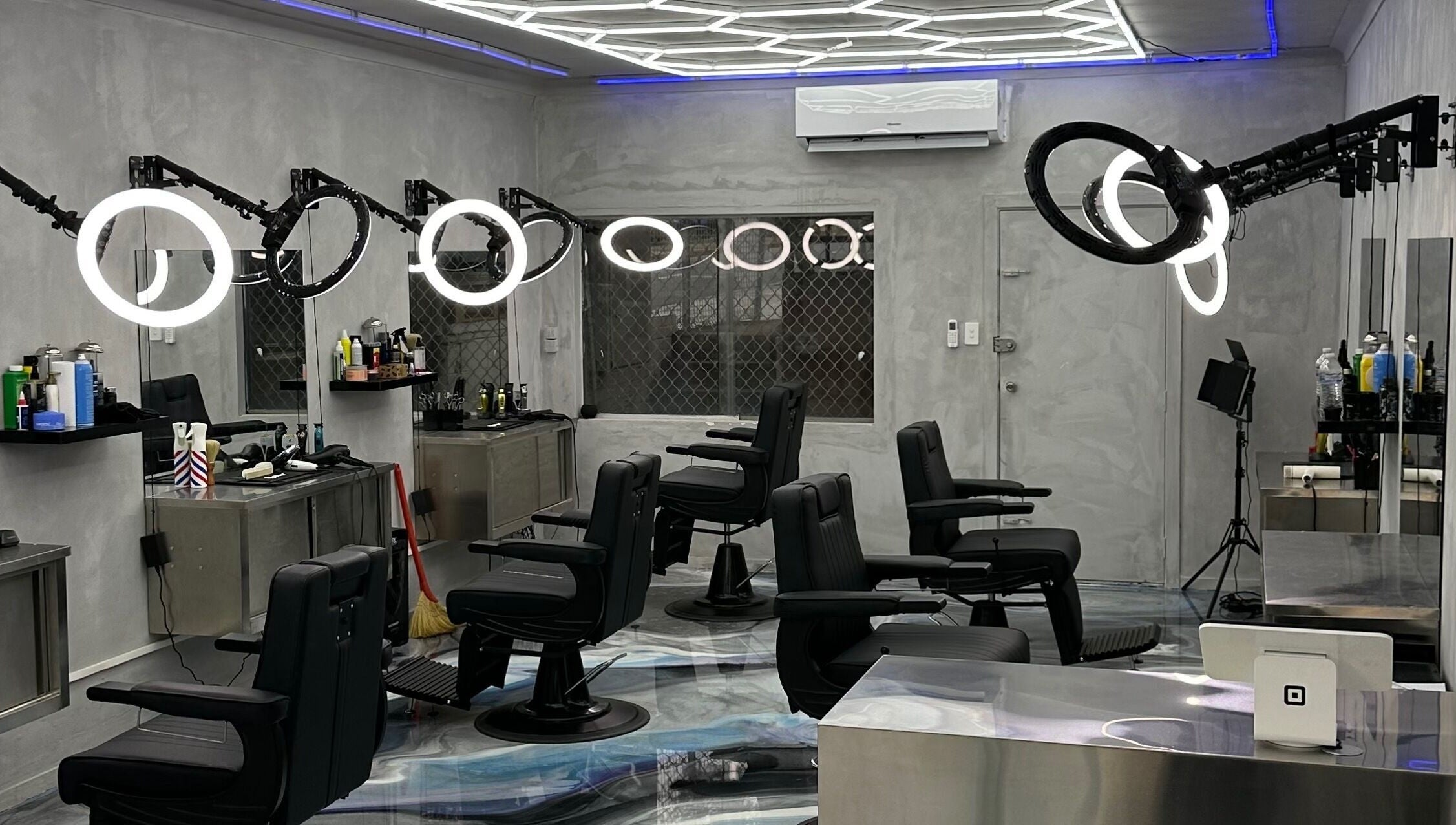 Modern interior of StudioBlendz Barbershop, Southport, Queensland, AU, featuring sleek black chairs and lighting.