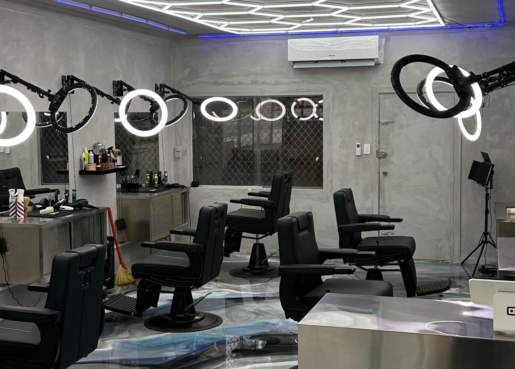 Modern interior of StudioBlendz Barbershop, Southport, Queensland, AU, featuring sleek black chairs and lighting.