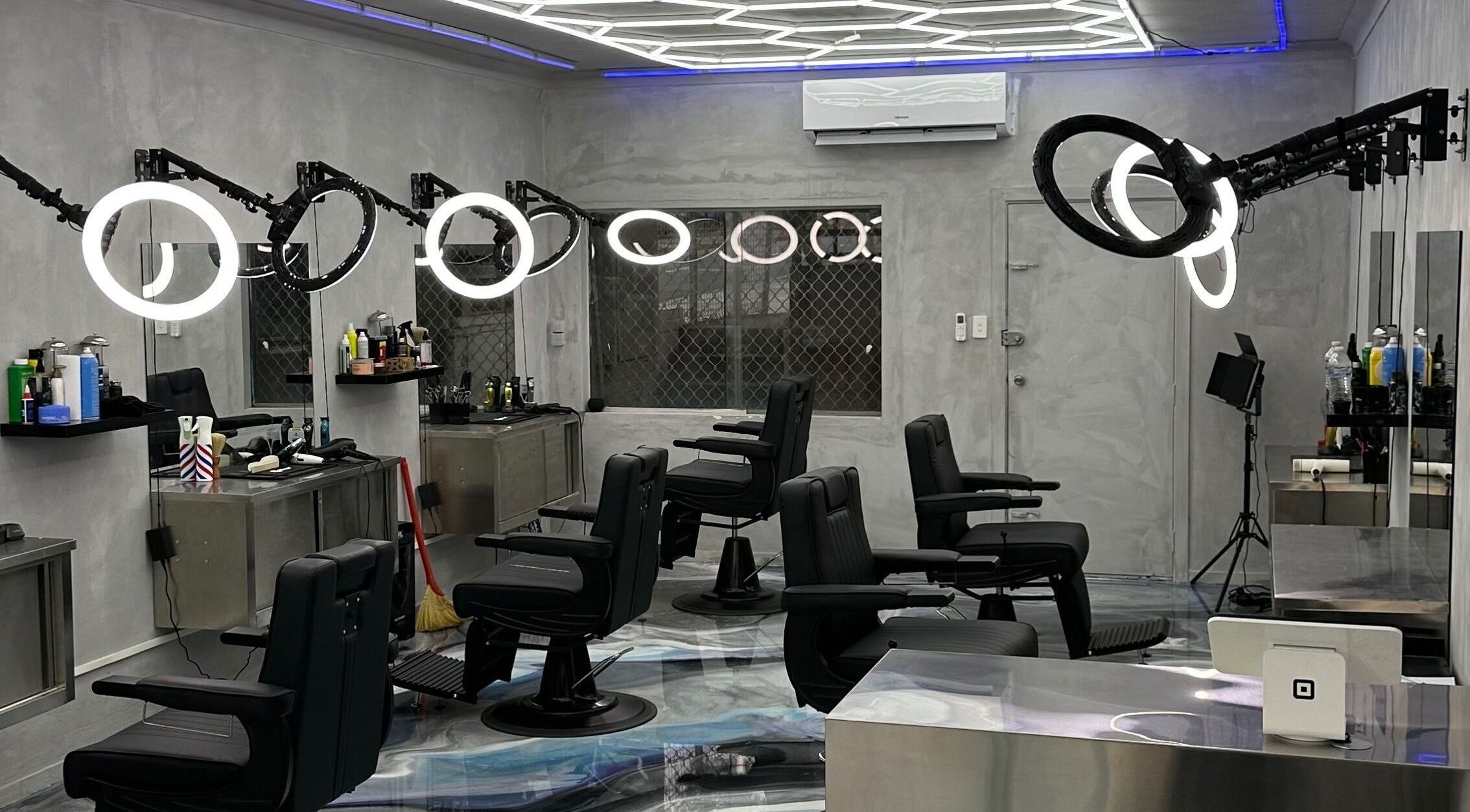 Modern interior of StudioBlendz Barbershop, Southport, Queensland, AU, featuring sleek black chairs and lighting.