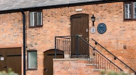 Entrance of Birch Barn Therapies, a rustic brick building in Castlethorpe, England, GB.