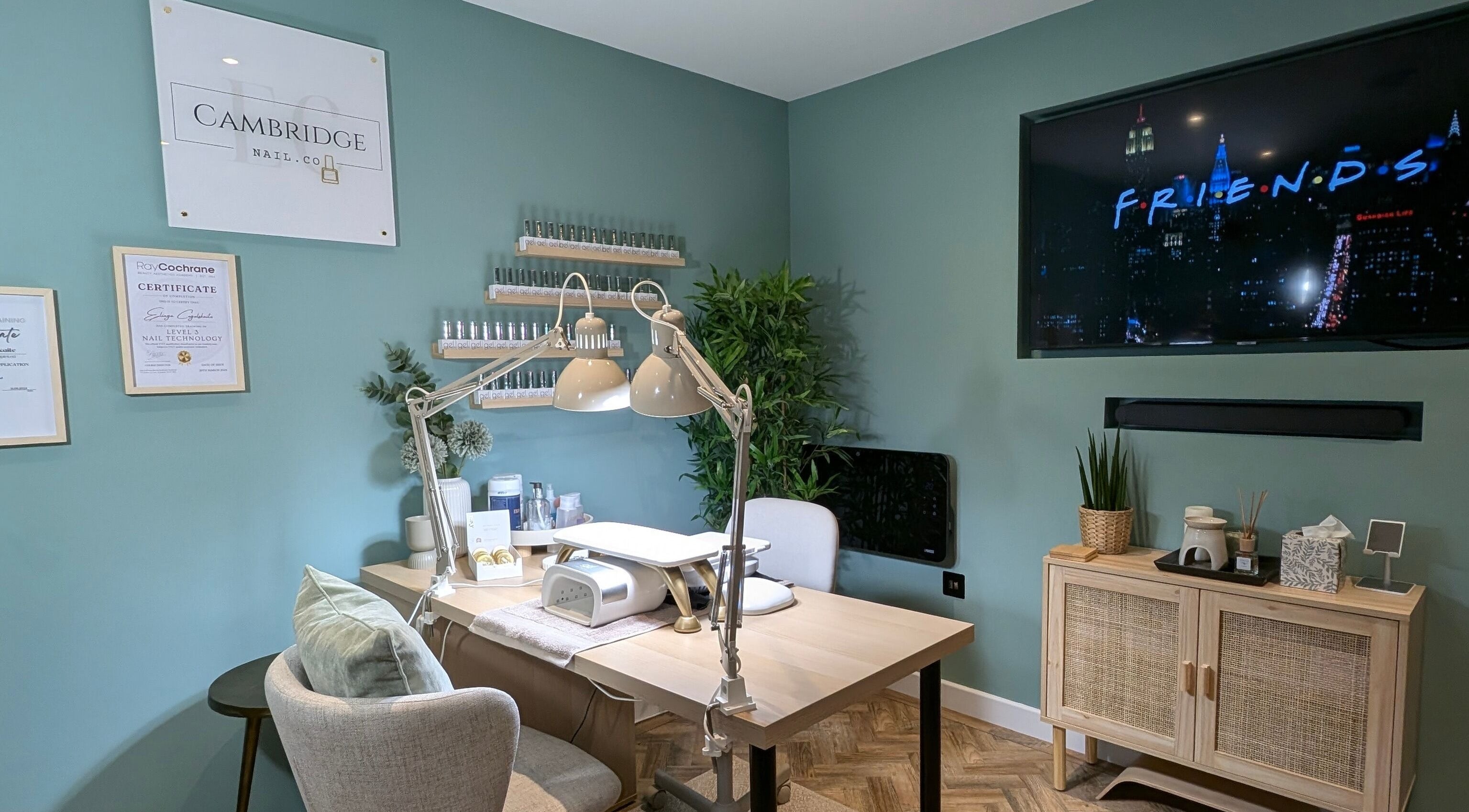 Elegant nail station at Cambridge Nail.co, Waterbeach, Cambridge, GB, showcasing certificates and stylish decor.