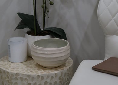 Elegant seating area at Aesthetics By Kristen in Wollongong, New South Wales, AU with a potted plant and decor.
