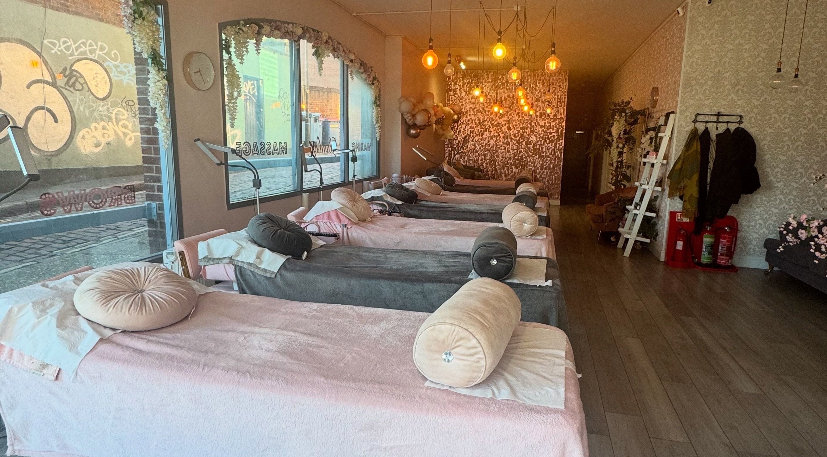 Elegant massage beds at Glambox in Norwich, England, GB, with ambient lighting and floral decor.