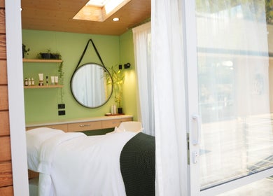 Relaxing treatment room at Hada Studio, Christchurch, Canterbury, NZ, featuring green decor and natural light.