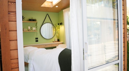 Relaxing treatment room at Hada Studio, Christchurch, Canterbury, NZ, featuring green decor and natural light.