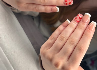 Beautiful nail art with red and white accents at Rock Candy Beauty, Louth, England, GB.