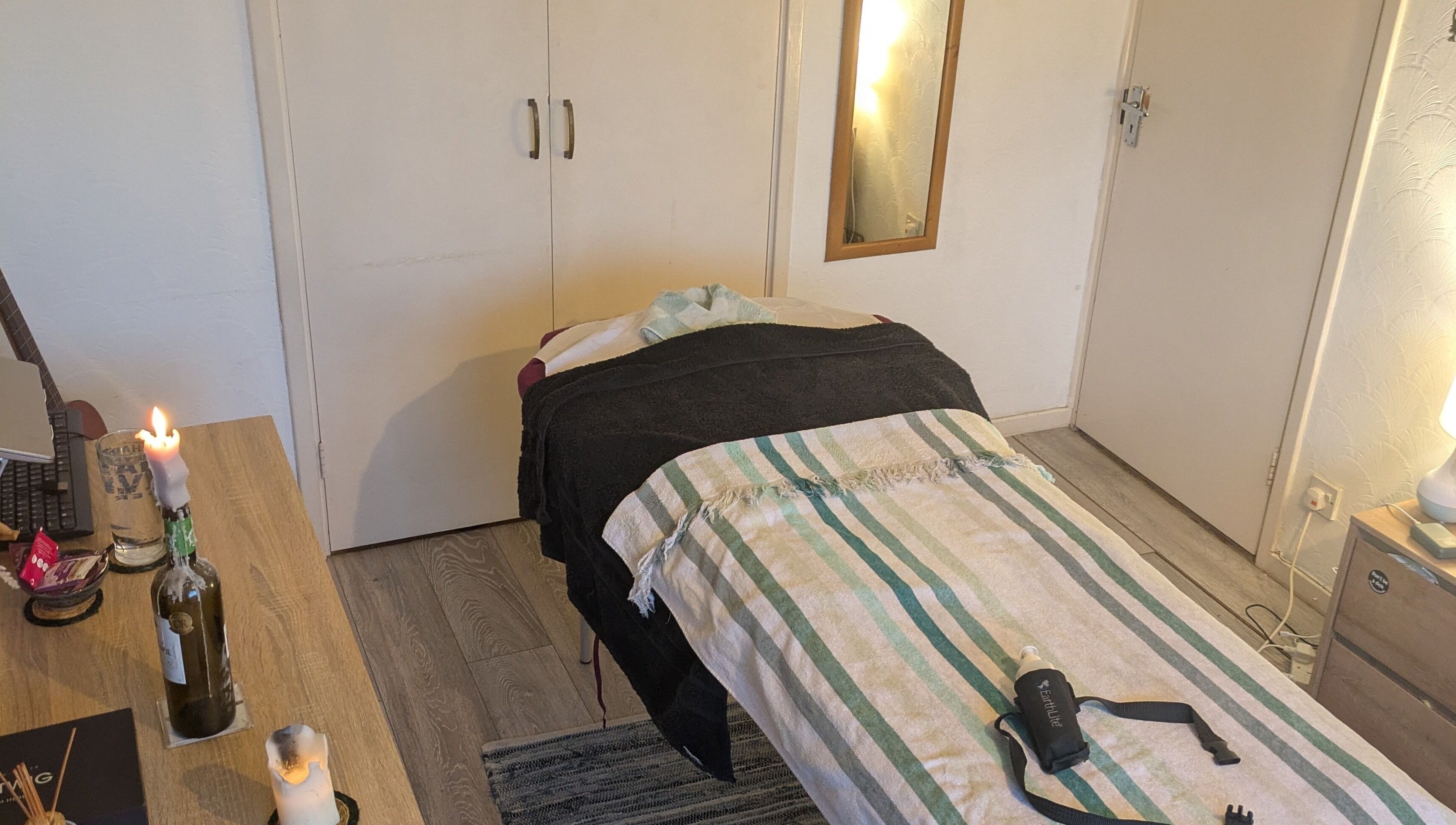 Tranquil massage room at Reviving Harmony, London. Cozy setting, candles, and soothing decor await your arrival.