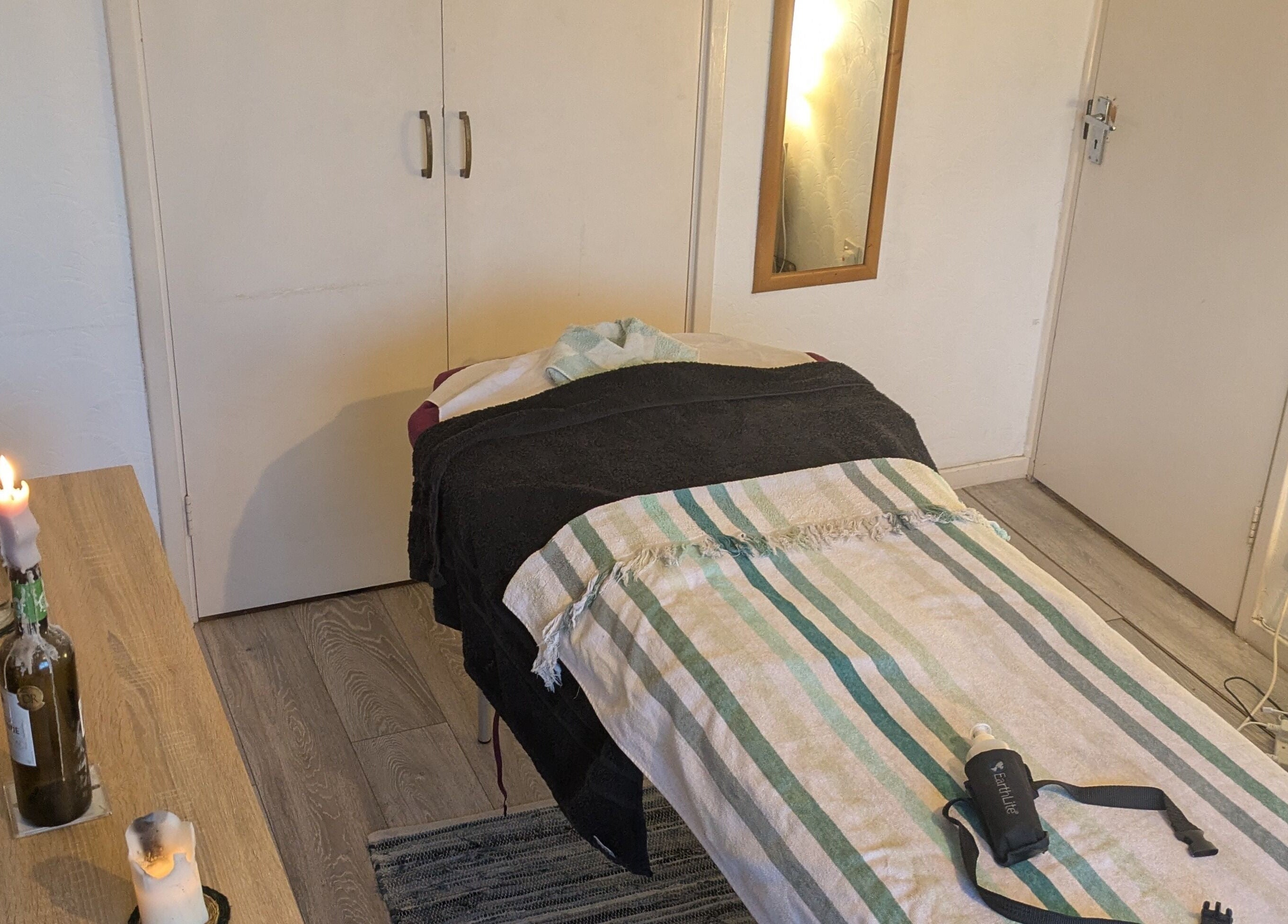 Tranquil massage room at Reviving Harmony, London. Cozy setting, candles, and soothing decor await your arrival.