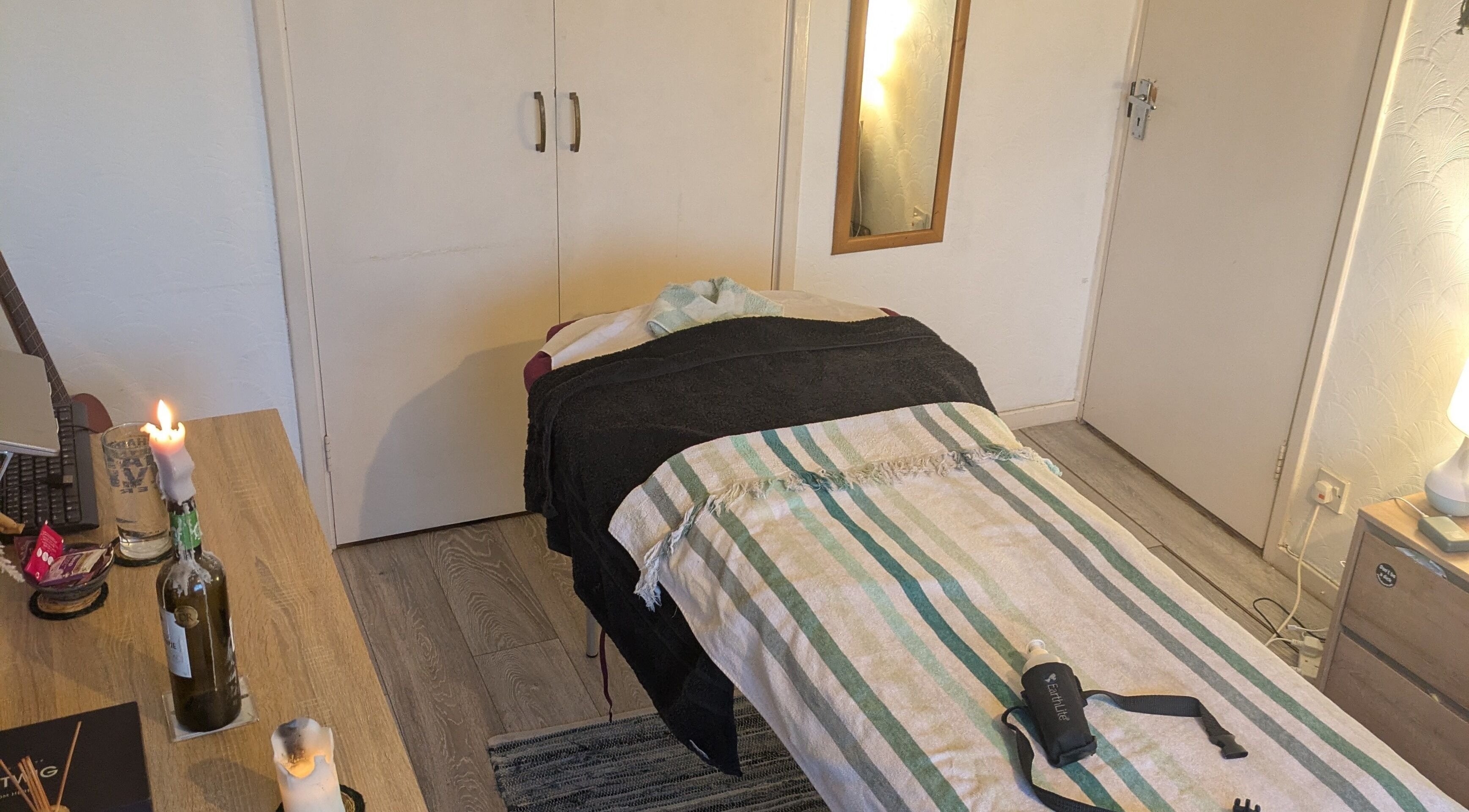 Tranquil massage room at Reviving Harmony, London. Cozy setting, candles, and soothing decor await your arrival.