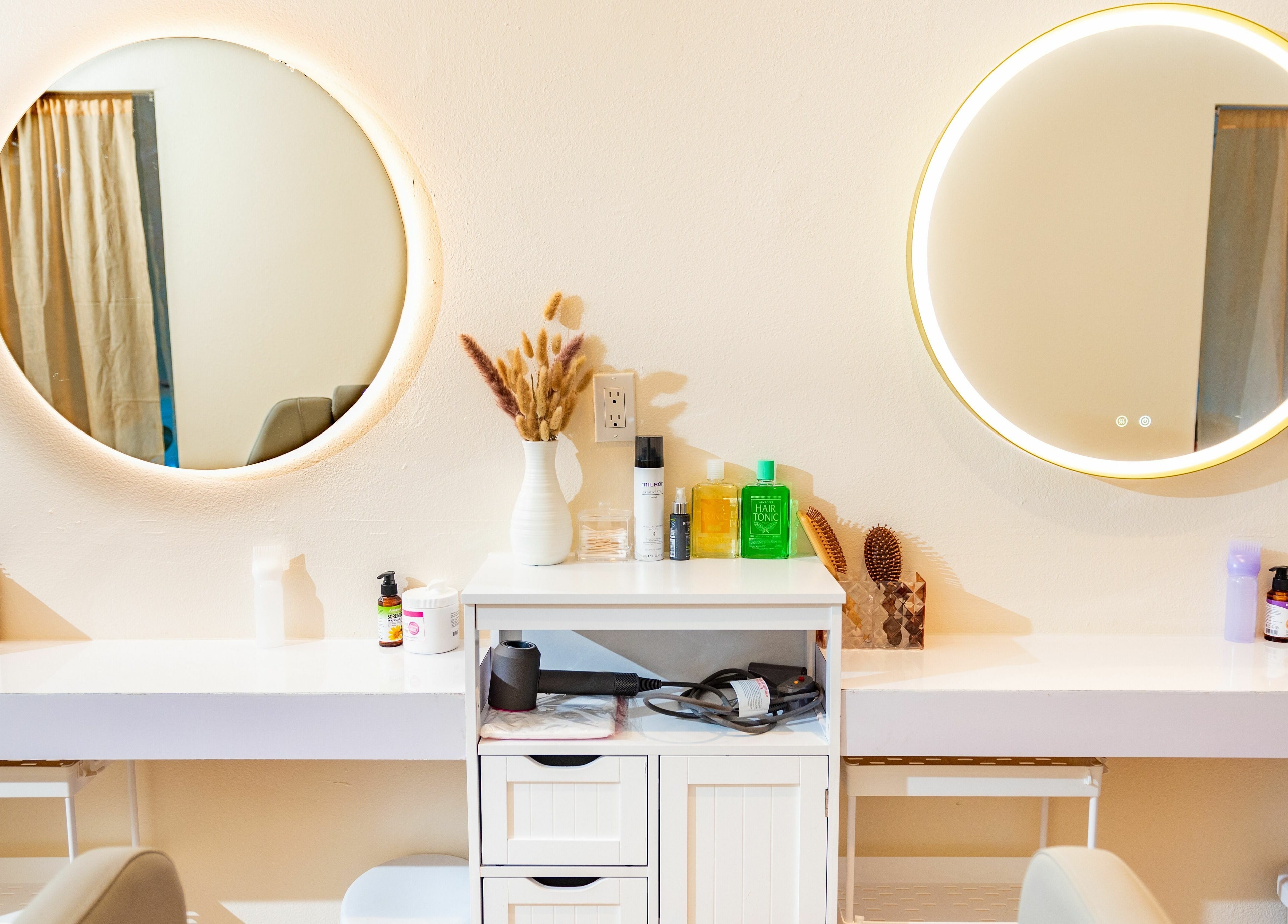 Chic vanity with round mirrors at Siyu Hair SPA, Henderson, Nevada, US, showcasing beauty products.