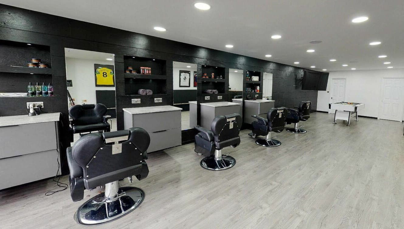 Modern interior of Kings Cuts in Epsom, England, GB with stylish barber chairs and mirrors.
