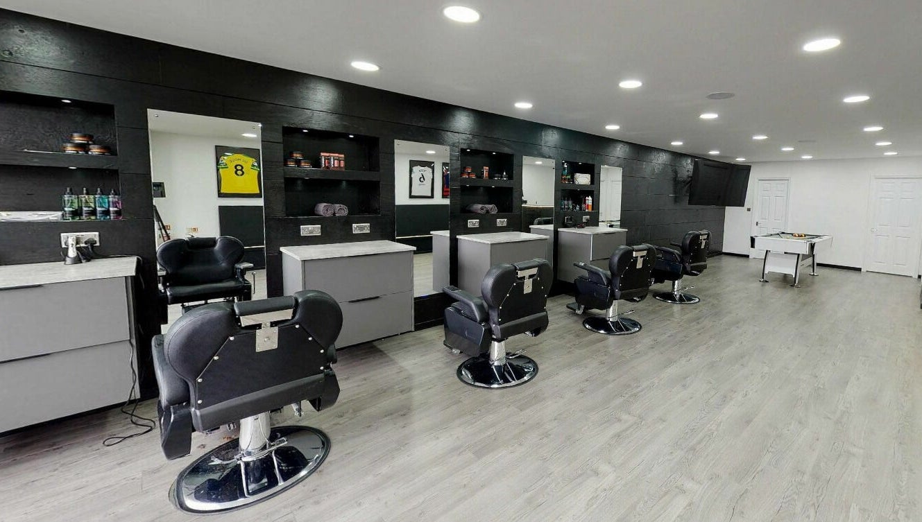 Modern interior of Kings Cuts in Epsom, England, GB with stylish barber chairs and mirrors.