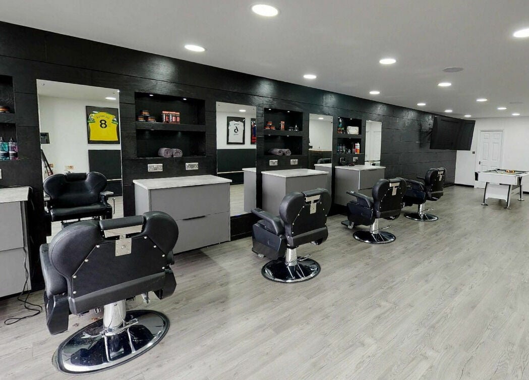 Modern interior of Kings Cuts in Epsom, England, GB with stylish barber chairs and mirrors.