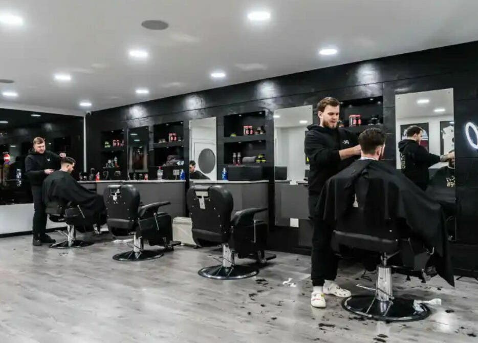 Modern interior of Kings Cuts barbershop in Epsom, England, GB, showcasing skilled barbers at work.