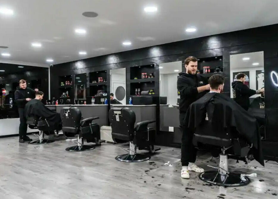 Modern interior of Kings Cuts barbershop in Epsom, England, GB, showcasing skilled barbers at work.