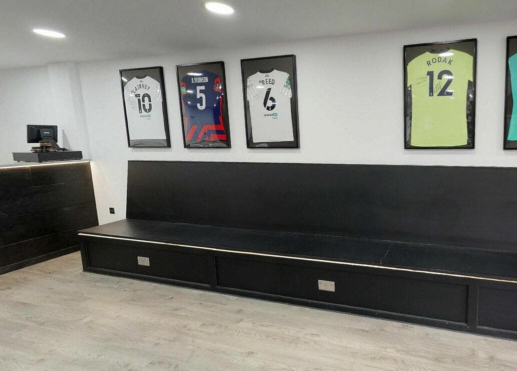 Modern waiting area at Kings Cuts with framed jerseys, located in Epsom, England, GB.