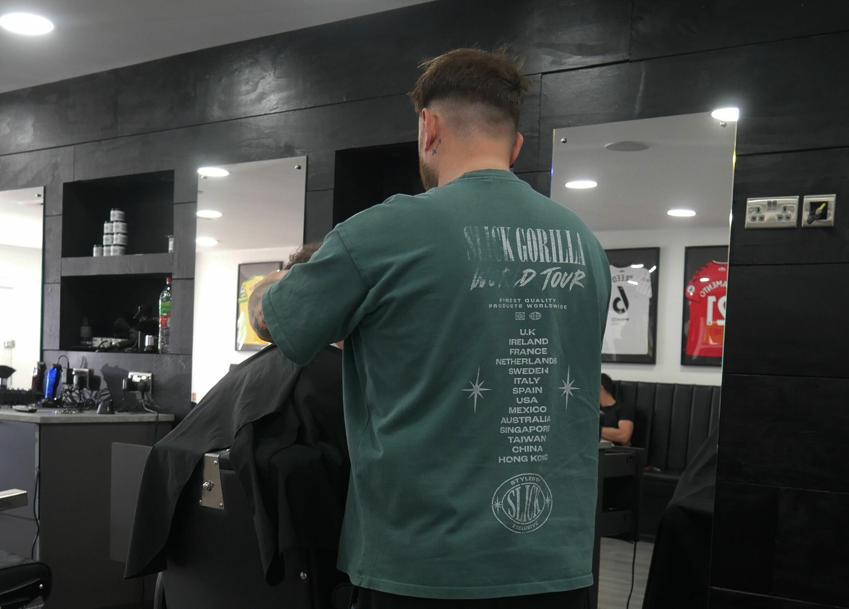 Barber styling hair at Kings Cuts in Epsom, England, GB, showcasing modern interior and design.