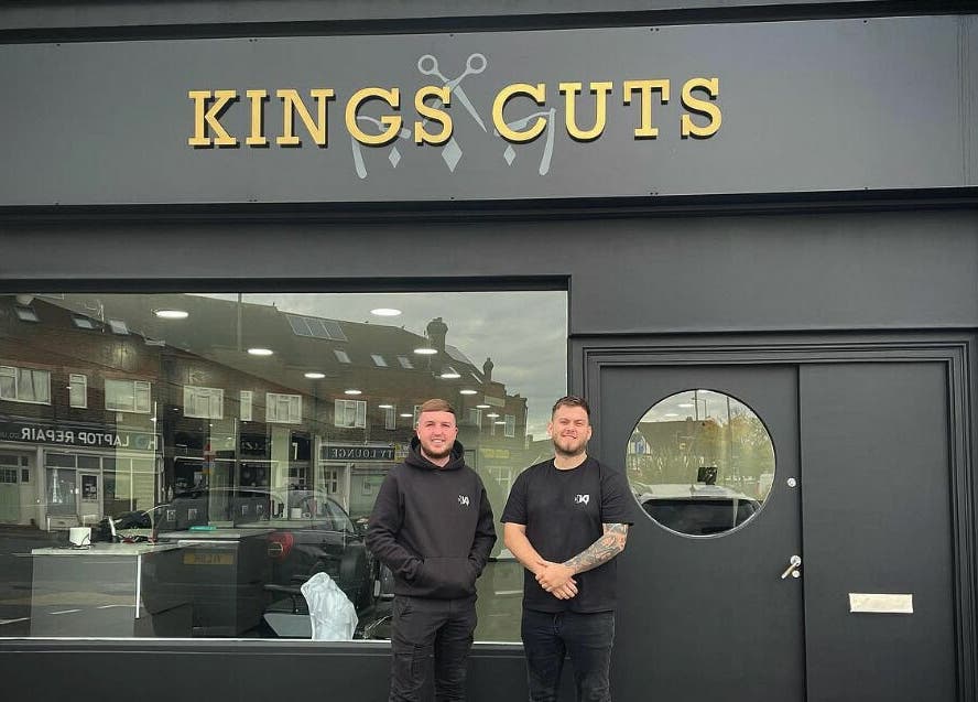 Exterior of Kings Cuts in Epsom, England, GB with two staff members standing outside.