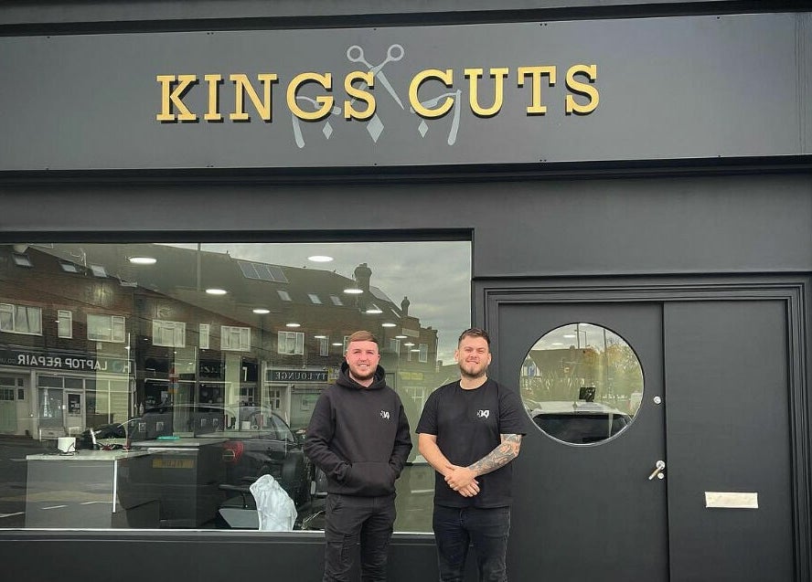 Exterior of Kings Cuts in Epsom, England, GB with two staff members standing outside.