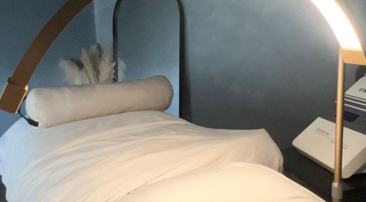 Luxurious treatment bed at Noney Skin, Glasgow, Scotland, GB, set in a calming spa environment.