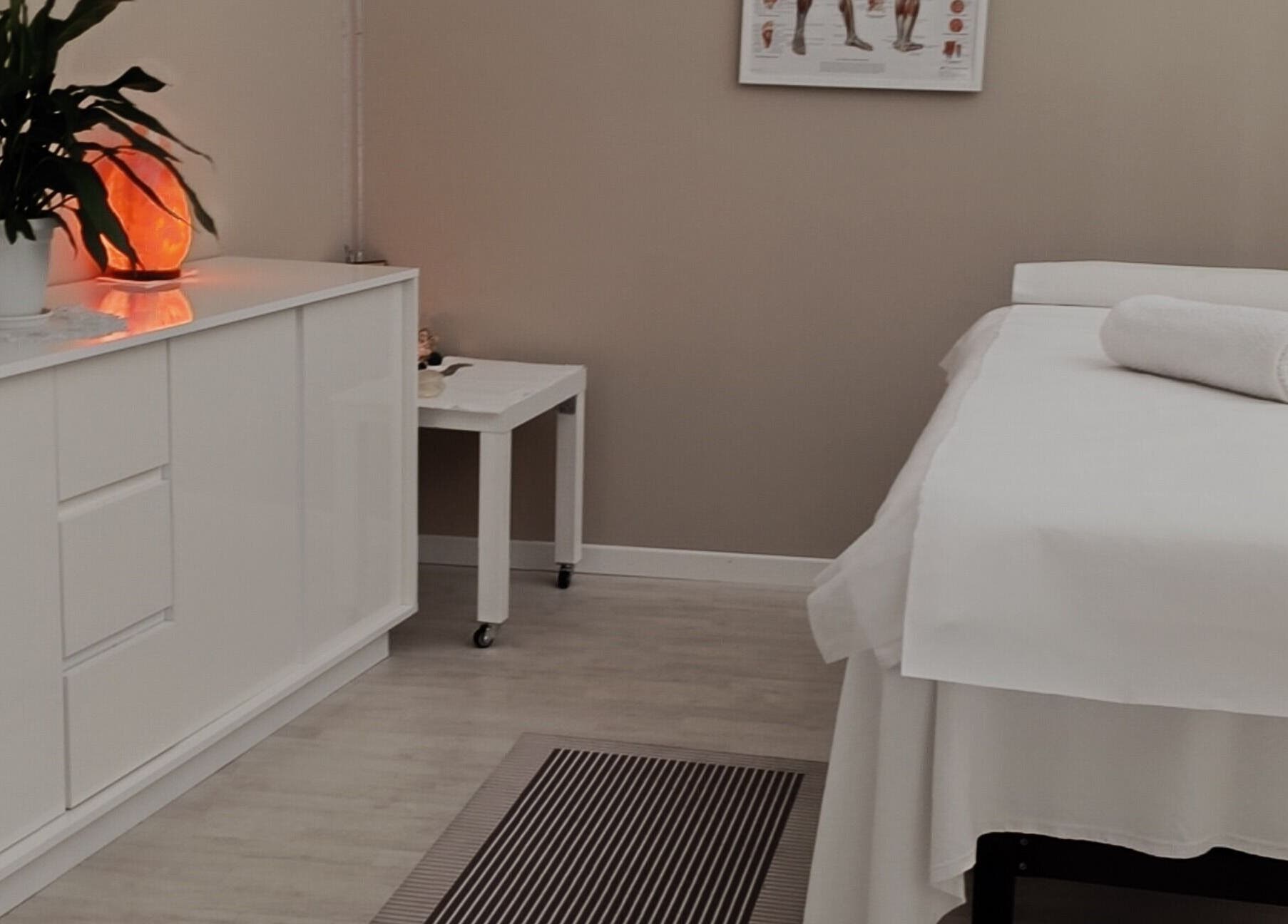 Sala massaggi elegante a Phoenix Studio, Padova, Veneto, IT con letto e lampada di sale.