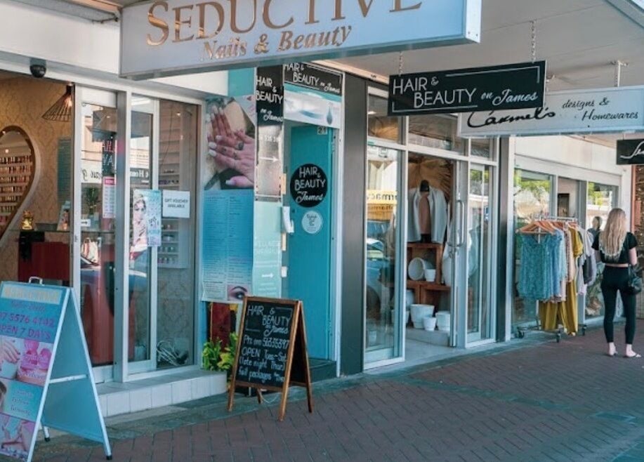 Street view of Happy Head Spa, Burleigh Heads, featuring stylish glass doors and beauty service signage.