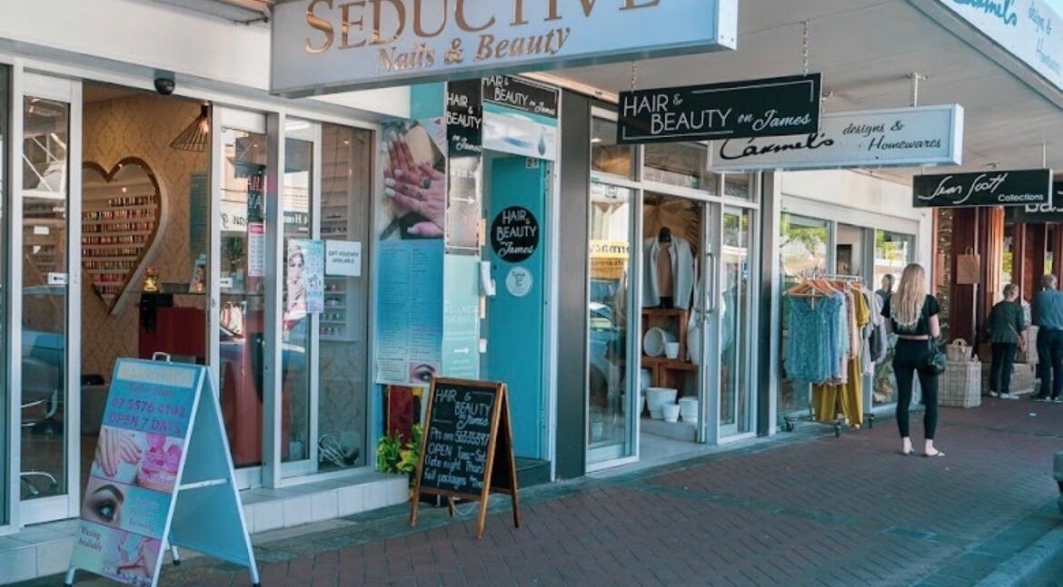 Street view of Happy Head Spa, Burleigh Heads, featuring stylish glass doors and beauty service signage.
