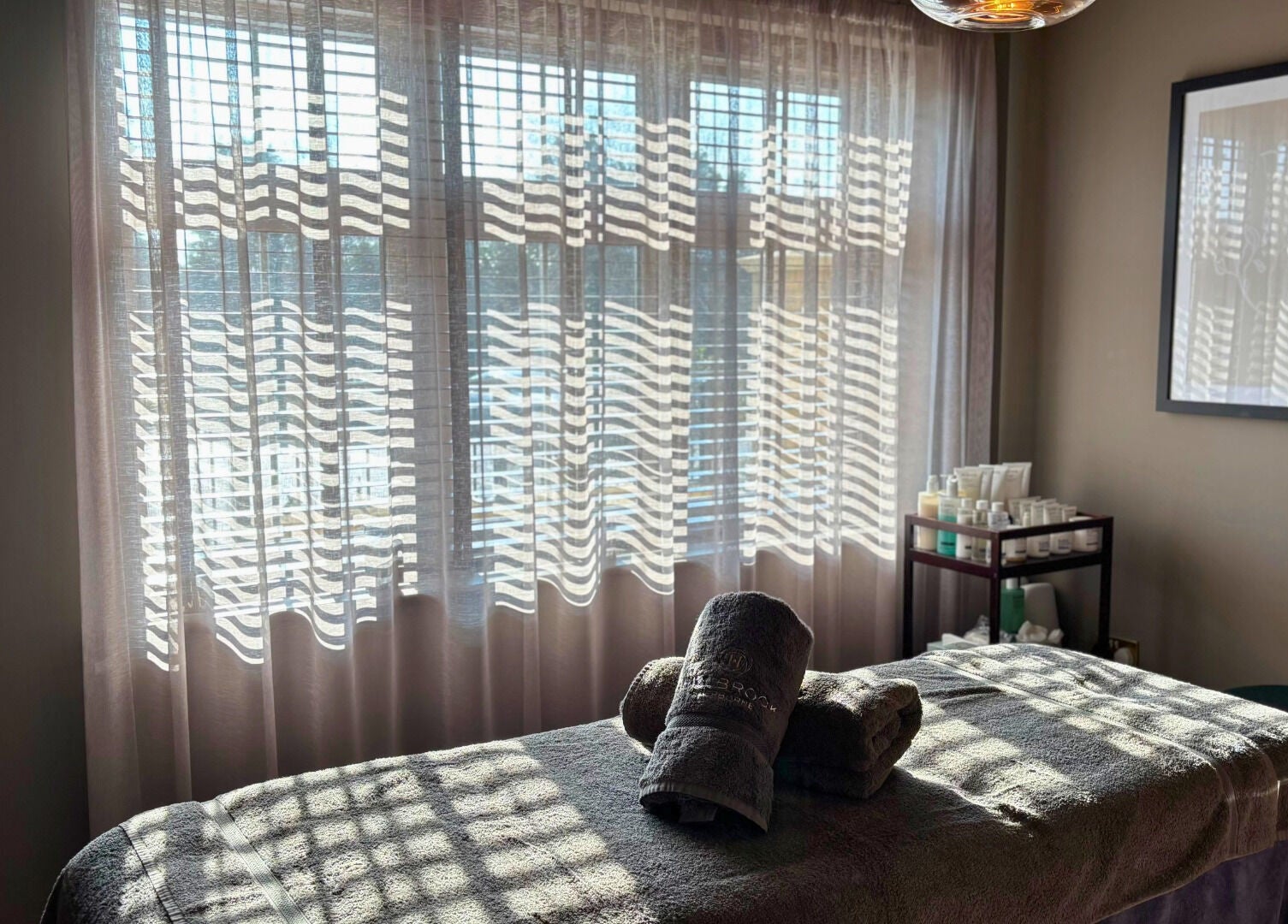 Peaceful spa room with massage table at The Hillbrook in Sherborne, England, GB, bathed in natural light.