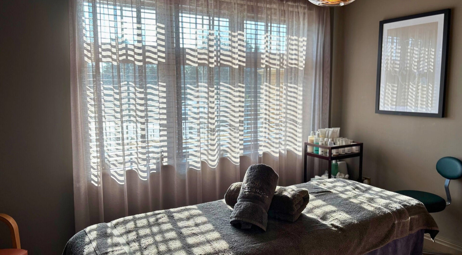 Peaceful spa room with massage table at The Hillbrook in Sherborne, England, GB, bathed in natural light.