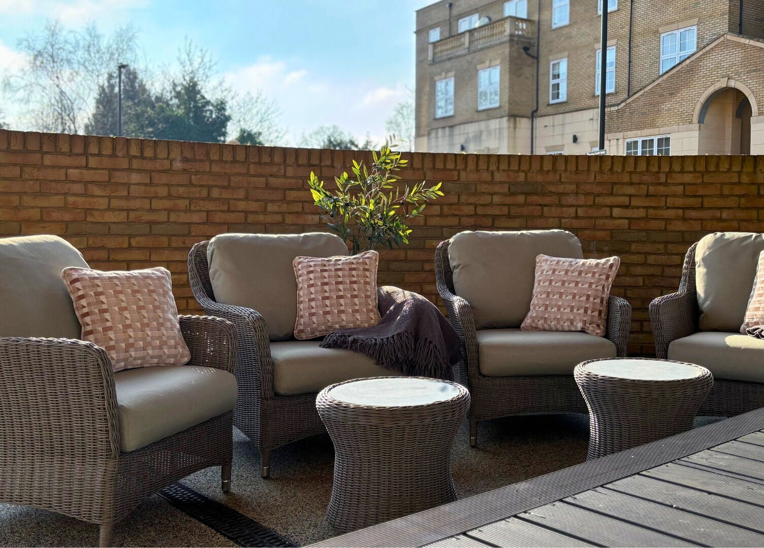 Elegant outdoor seating at The Hillbrook, Sherborne, England, GB with wicker chairs and lush surroundings.