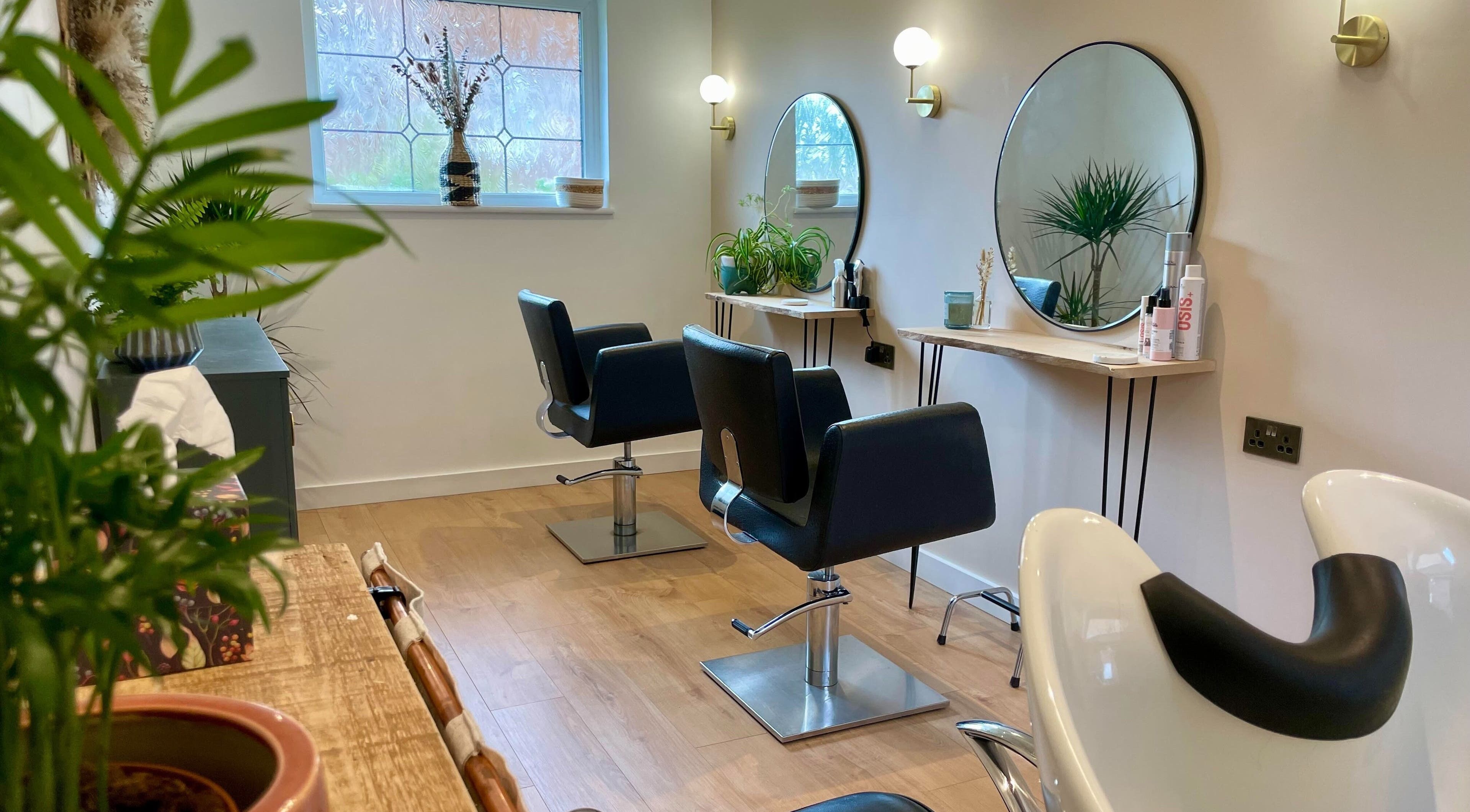 Modern beauty salon at Wildmoor Hair Co., Sandhurst, UK, featuring chic chairs and stylish decor.