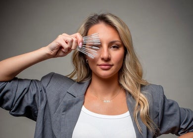 Woman displays eyelash brushes at Lash Eyelashes, Southampton, England, GB for beauty enhancement.