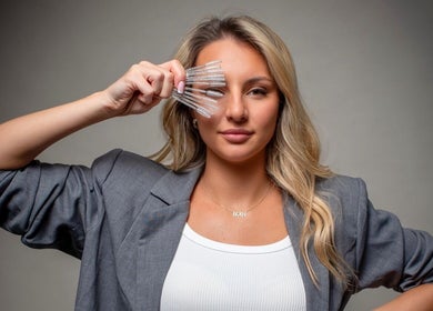 Woman showcasing eyelash tools at Lash Eyelashes, Southampton, England, GB.