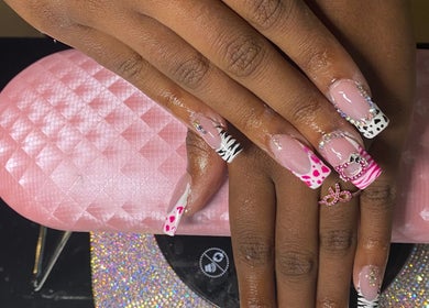 Stylish nail art at Naileditby_des in Paulsboro, New Jersey, US featuring pink glitter designs and accessories.
