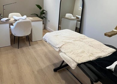 Peaceful treatment room at Hollie Louise Beauty in Tavistock, England, GB featuring a cozy chair and table setup.