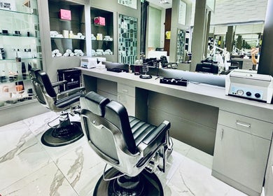 Sleek barber chairs at Big City Barbershop in Dubai, Dubai, AE with stylish reflective mirrors and shelves.