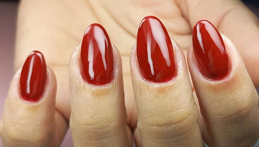 Unhas vermelhas sofisticadas no Studio Sister's, Peruíbe, São Paulo, BR, destacando beleza atemporal.