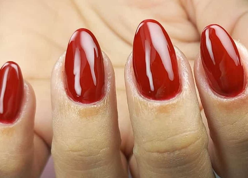 Unhas vermelhas elegantes no Studio Sister's em Peruibe, São Paulo, BR, realçando beleza e estilo.