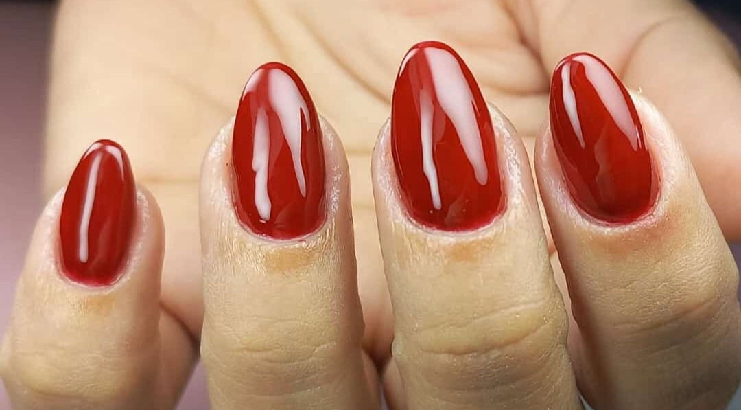 Unhas vermelhas elegantes no Studio Sister's em Peruibe, São Paulo, BR, realçando beleza e estilo.