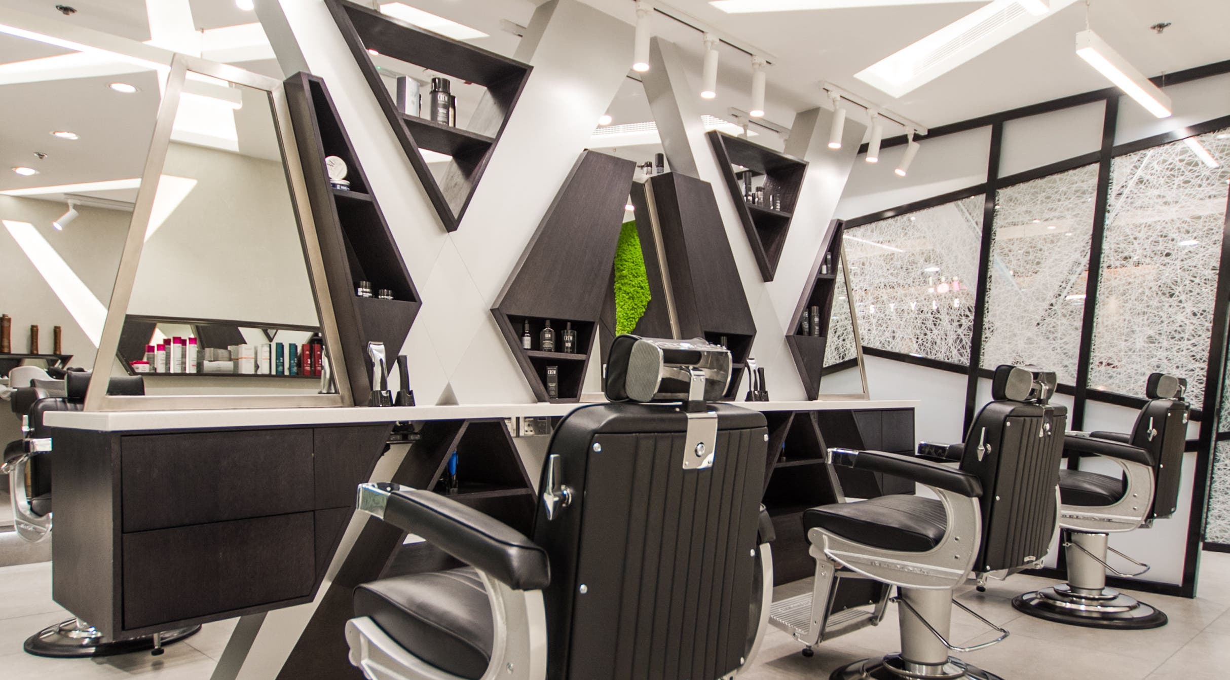 Modern interior of X Hair Lounge - City Centre Deira in Dubai, AE, showcasing stylish barber chairs and design.