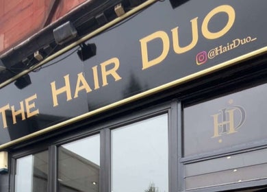 The Hair Duo storefront signage at Airdrie, Scotland, GB, showcasing bold lettering and a sleek exterior.