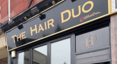 The Hair Duo storefront signage at Airdrie, Scotland, GB, showcasing bold lettering and a sleek exterior.