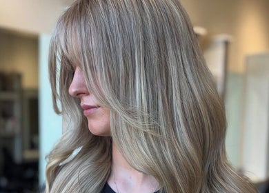 Elegant blonde hairstyle at The Hair Duo, Airdrie, Scotland, GB featuring layered waves.
