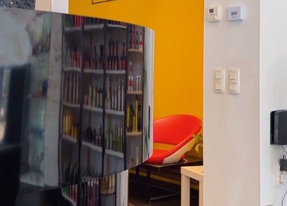 Binnenkant van HYPE BARBERSHOP in Antwerpen, Vlaams Gewest, BE met kleurrijke stoelen en producten.