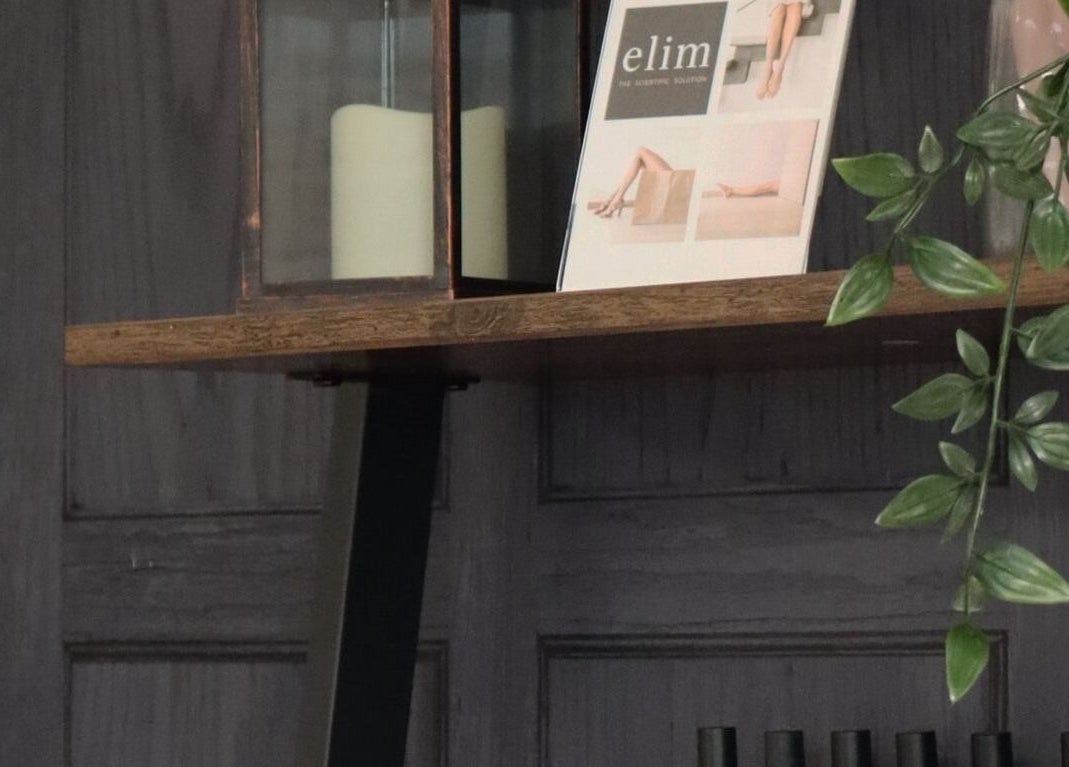 Rustic shelf at KL Nail Studio, Newtown, Wales, with decor and greenery, creating a tranquil vibe.