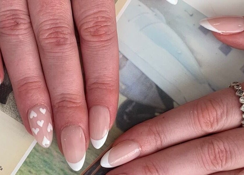 Elegant French manicure with heart designs at Cutie Pai Nails, Bali, Bali, ID.