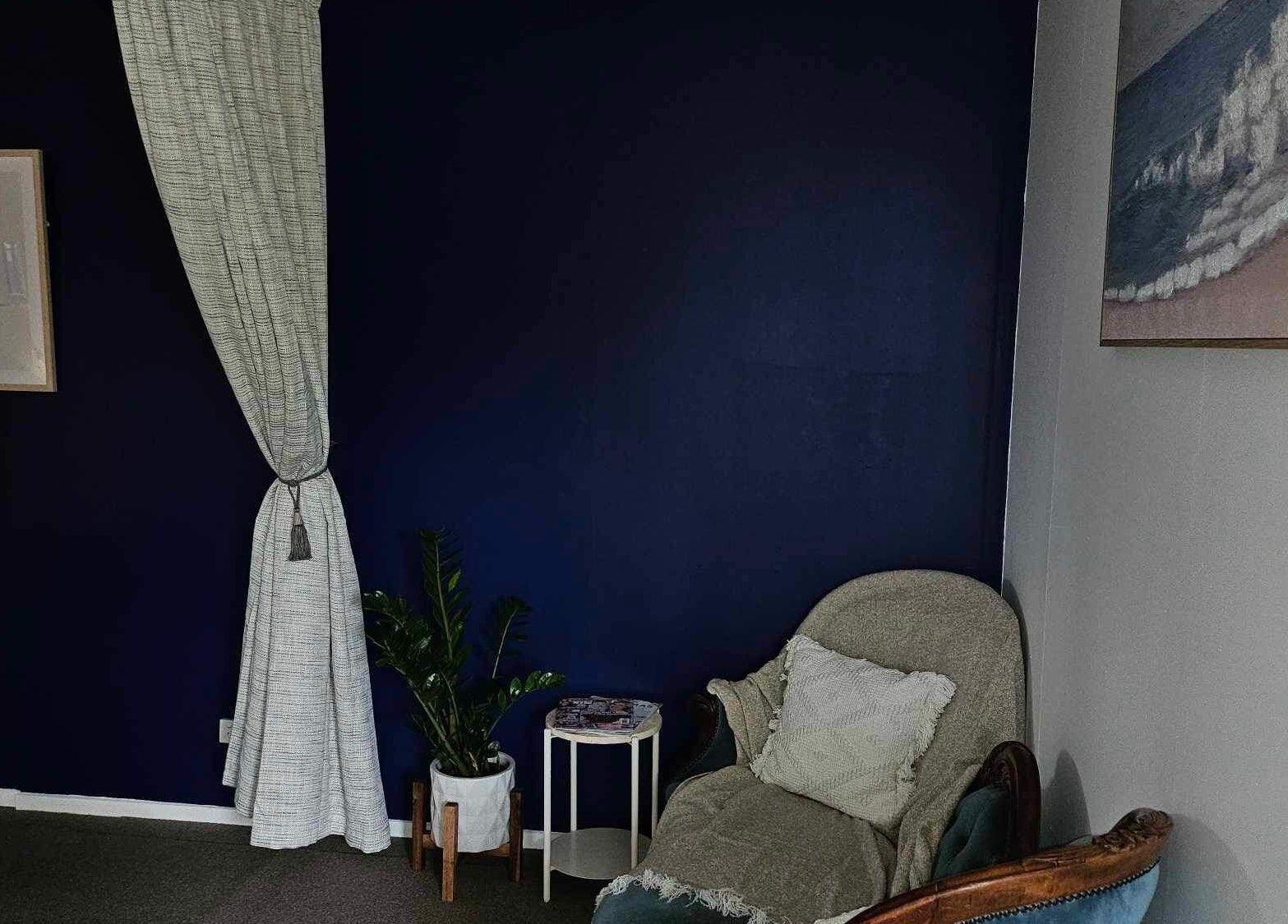 A cozy seating area with a navy wall at Whaitere Ora, Gisborne, Gisborne, NZ.