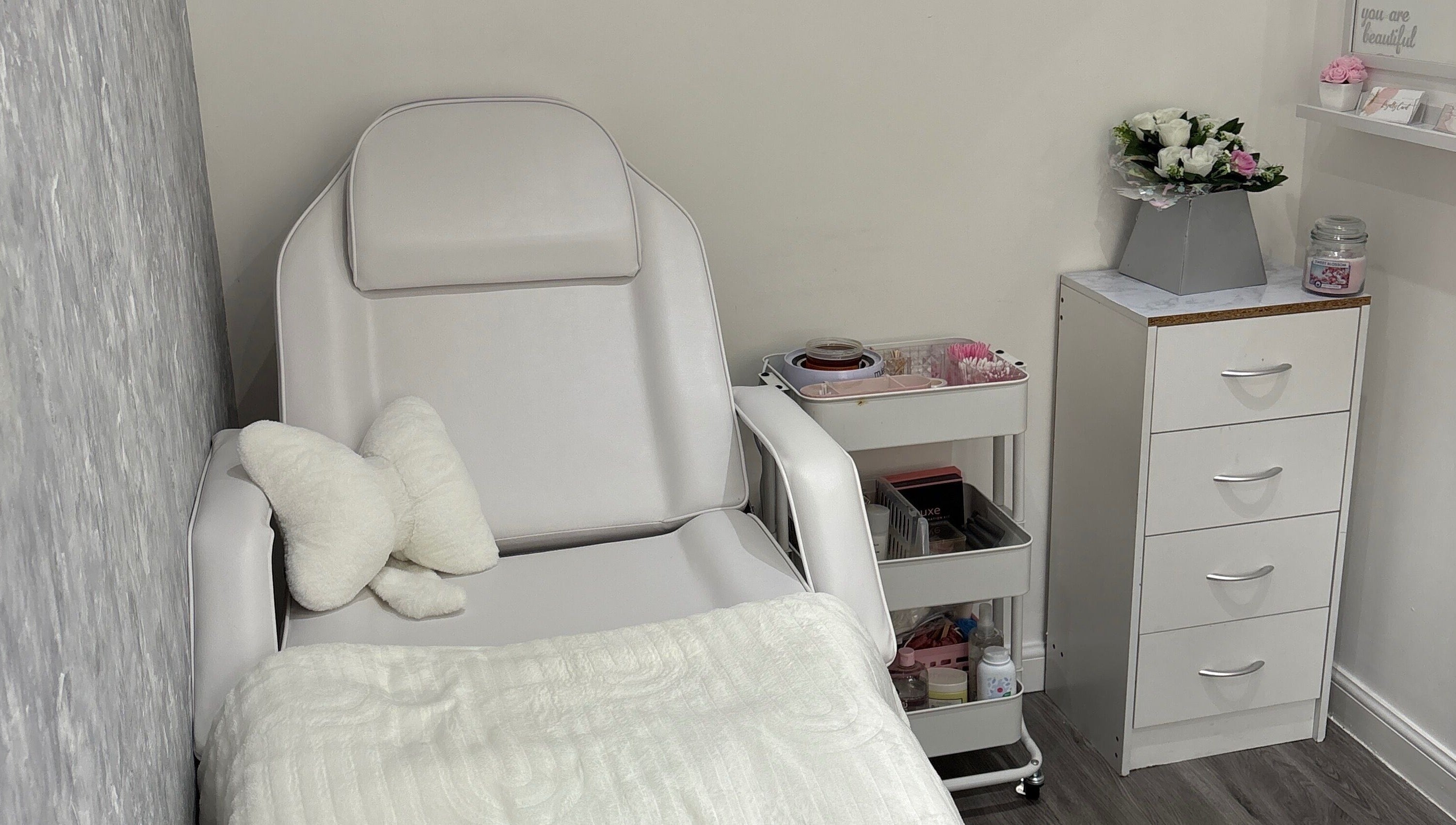 Cozy beauty treatment room at Ella Louise Beautyy, Rochdale, England, GB with plush chair and floral decor.