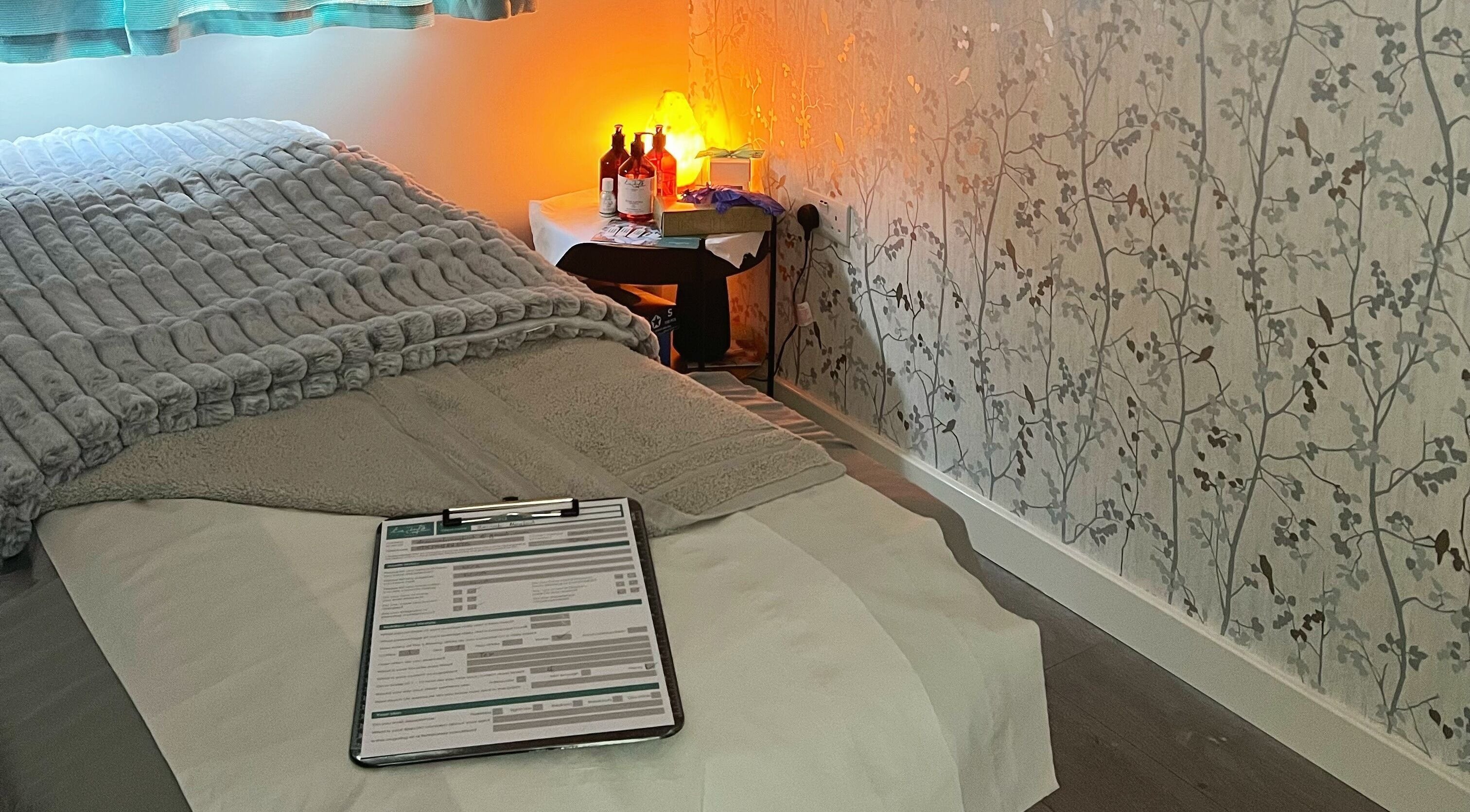 Relaxing treatment room at YG Beauty, Middlesbrough, GB with cozy bed and soft lighting.